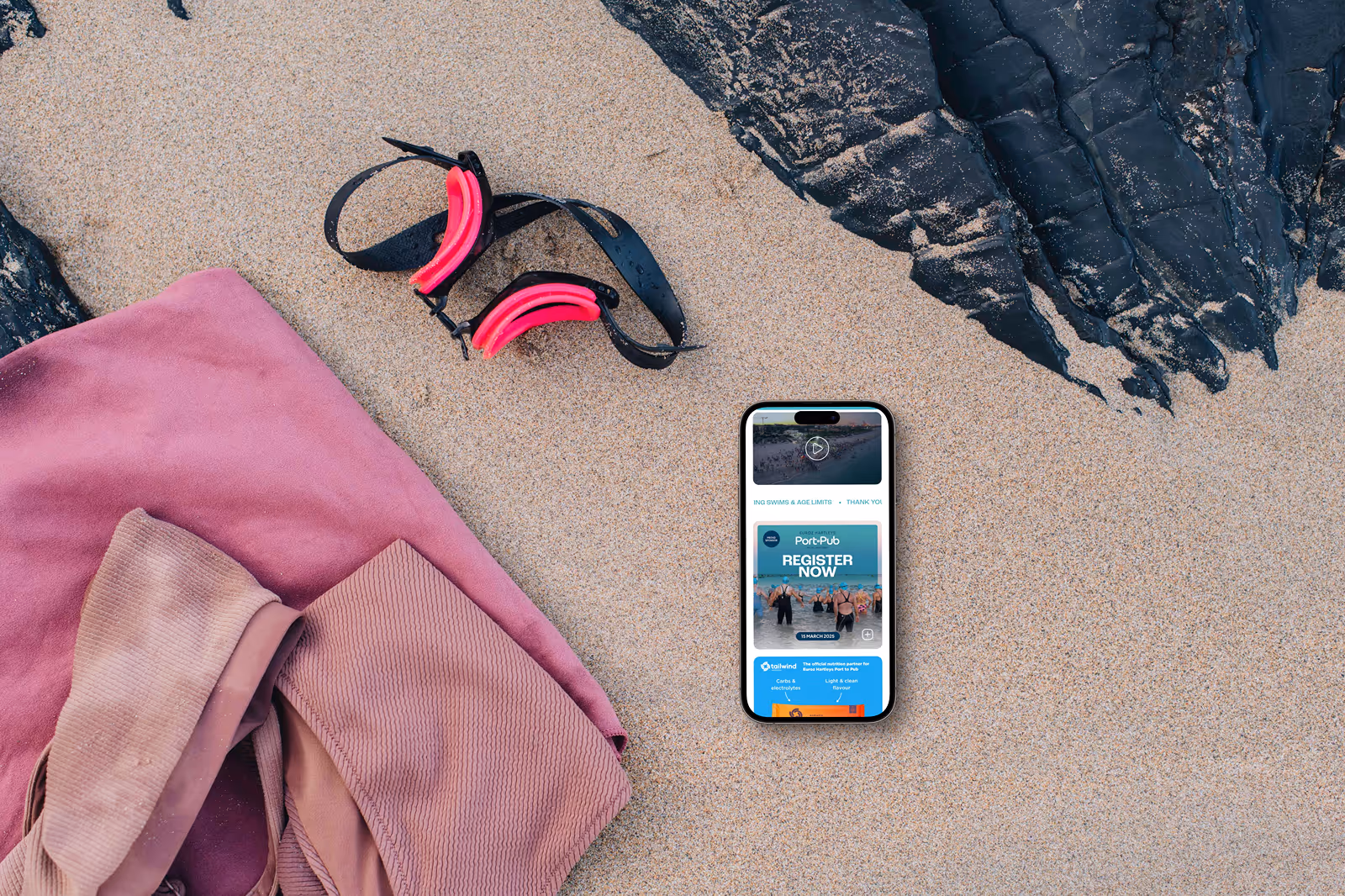 Port to Pub Website on an iPhone laying on the beach.