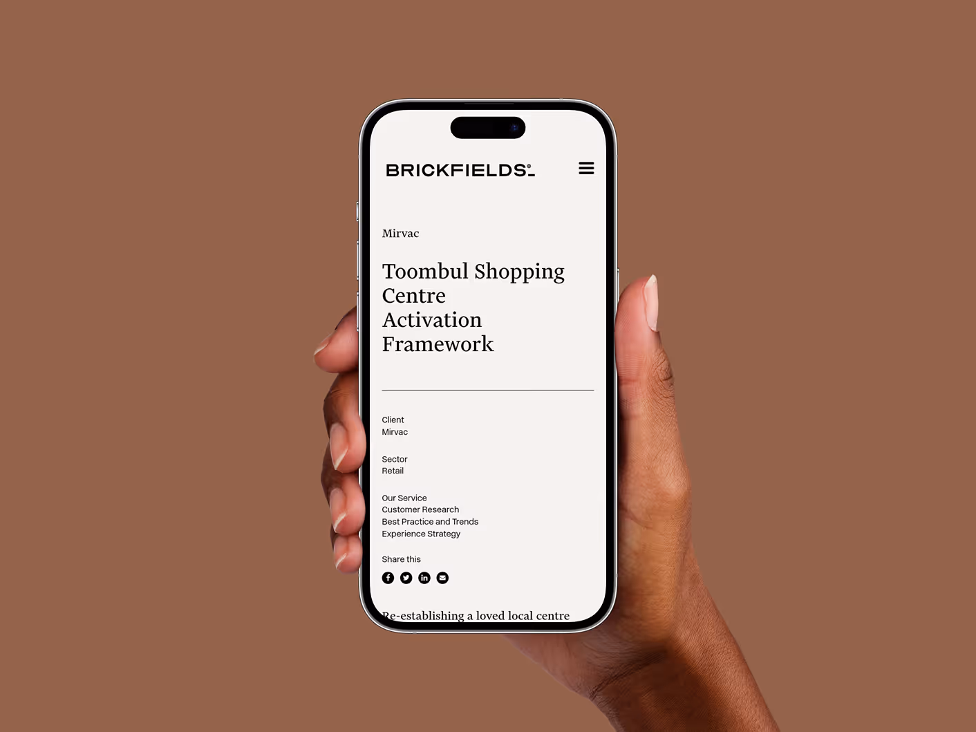 Hand holding iPhone with Brickfields Mirvac project page open
